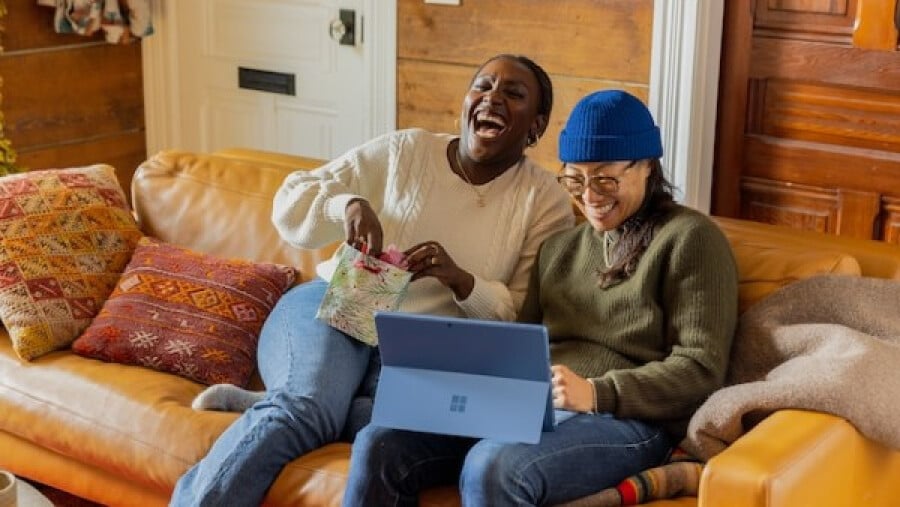friends sitting on a couch with a laptop