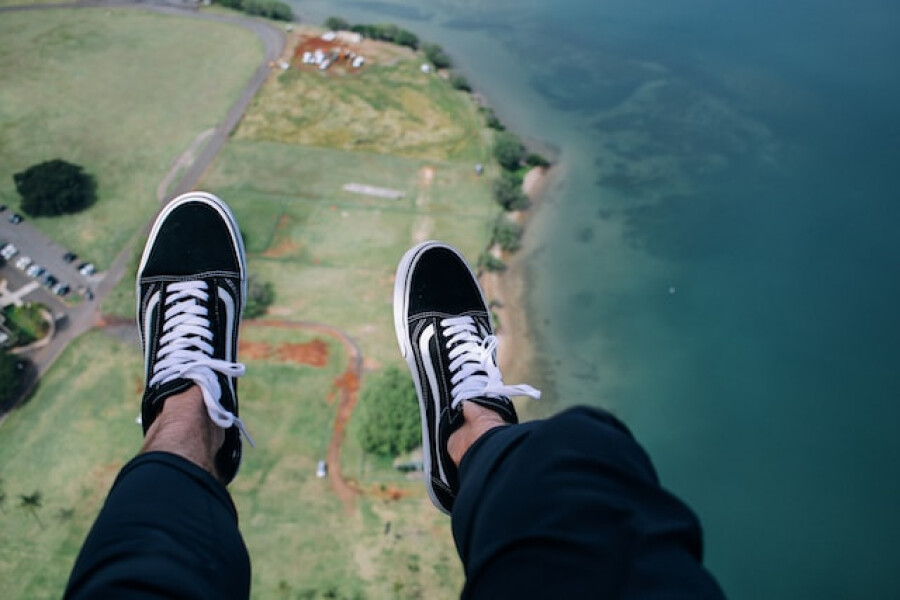 person wearing blue-and-white VANS looking out of aircraft