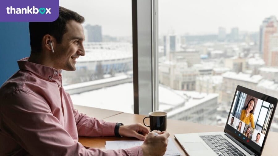 Side view of man having an online video call with coworkers