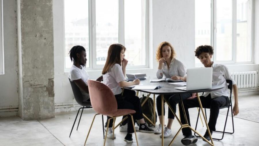 Focused diverse colleagues analysing project together in an office