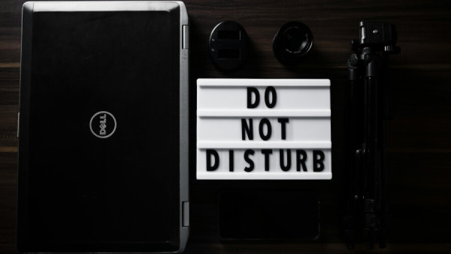 Overhead shot of a lighted letterboard beside a laptop