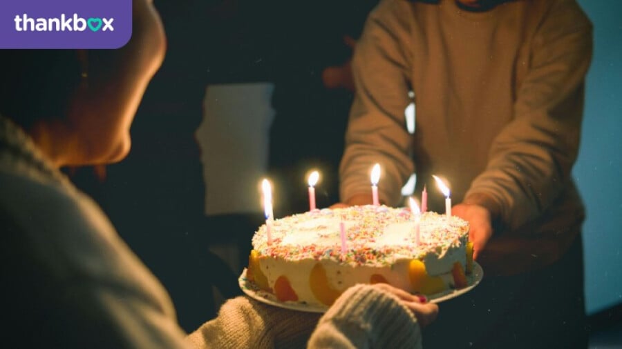 Two People Holding Cake With Lit Candles