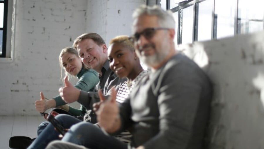 Cheerful friends with thumbs up