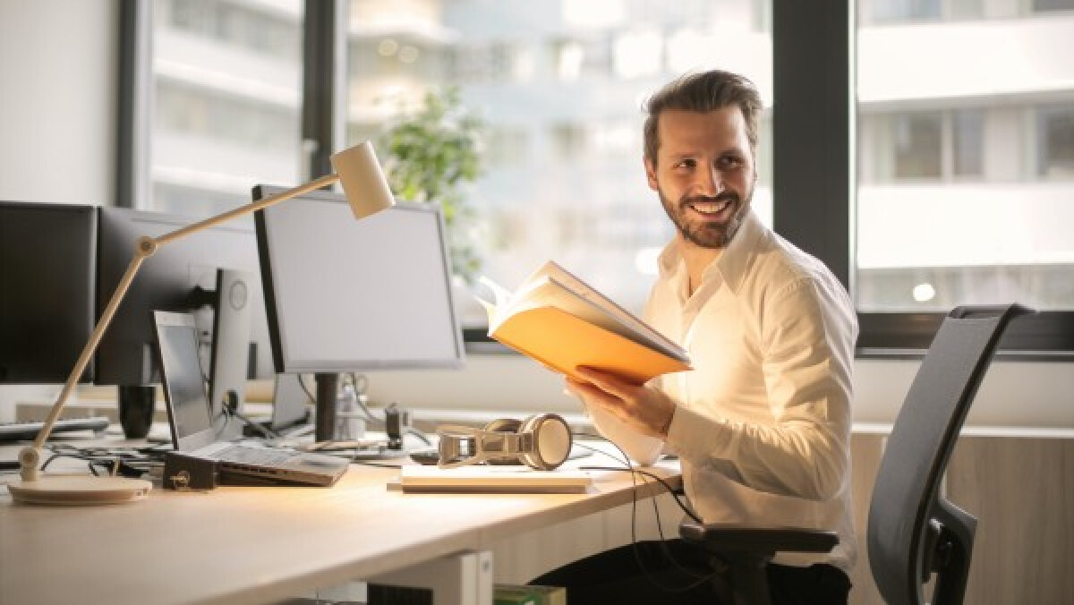 A man holding a notebook in the office