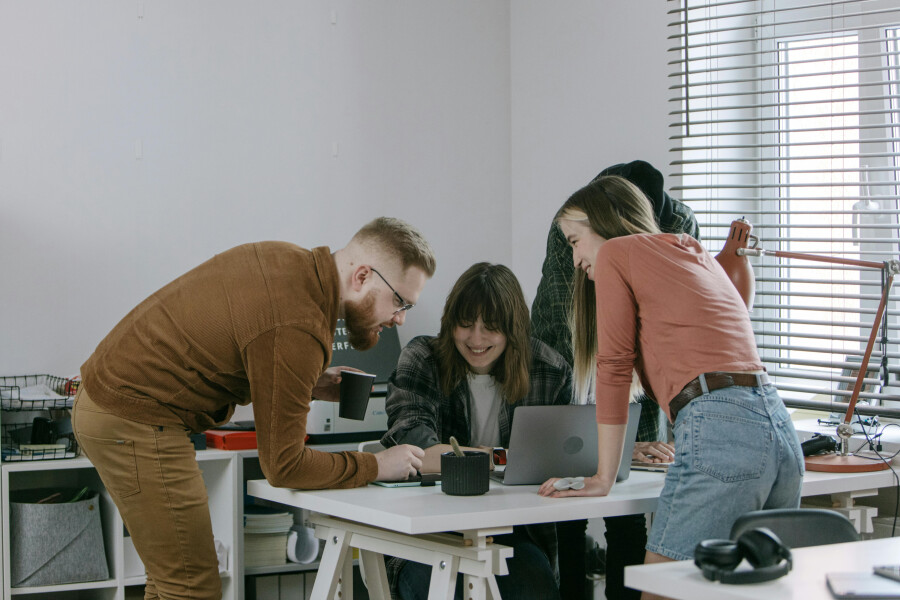 Group of People Standing Around a Desk