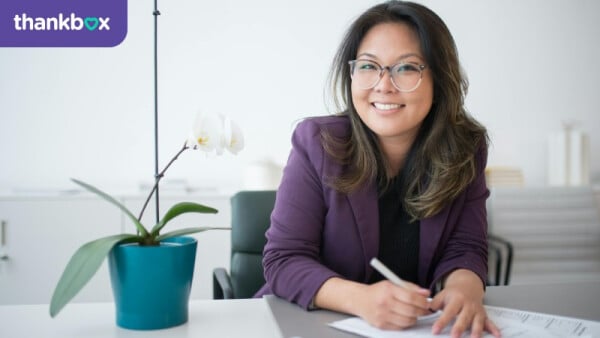 Woman sitting on a table and filling out papers