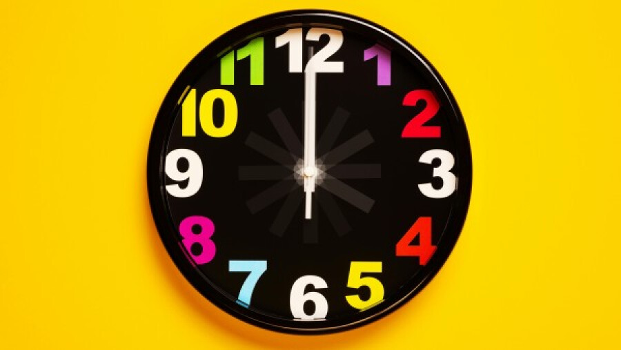 Black clock on a yellow wall