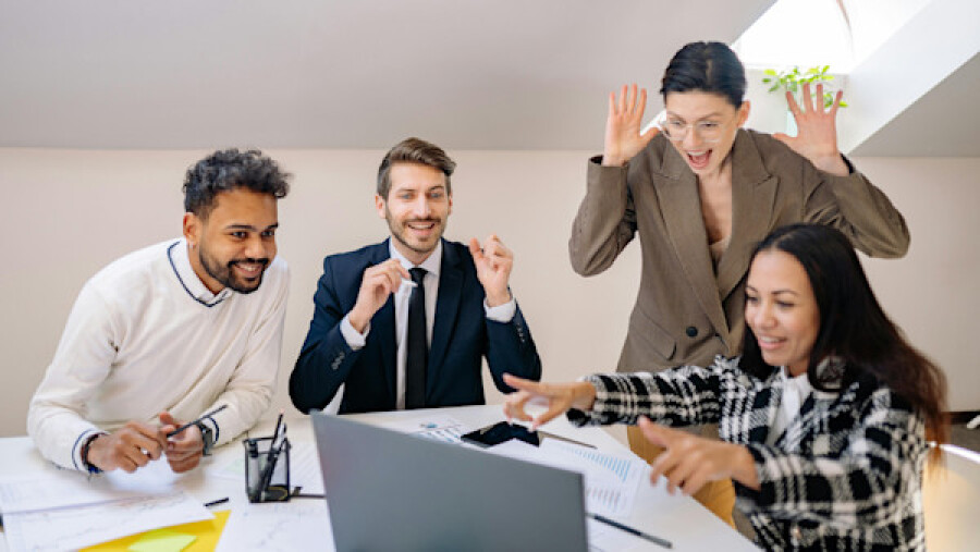 A Group of Happy People Looking at a Laptop