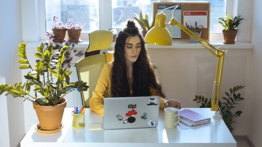 Woman in Yellow Jacket Working in Her Computer